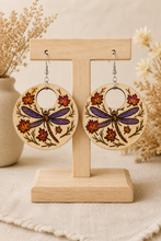 Cargar imagen en el visor de la galería, Vertical view of Autumn Wings hand-painted wooden earrings displayed on a light wood stand.