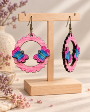 Cargar imagen en el visor de la galería, Mariposa Serena wooden earrings shown at an angle to highlight the raised hand-painted butterfly pieces