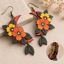 Cargar imagen en el visor de la galería, Moon Flower wooden earrings shown at an angle highlighting layered flowers, engraved leaves, and hand-painted texture