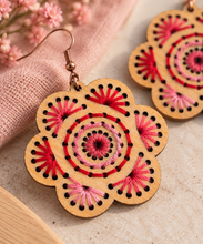 Cargar imagen en el visor de la galería, Close-up of Natural Splendor wooden earrings showing hand-embroidered red and pink stitching, natural wood grain, and bronze-tone hook