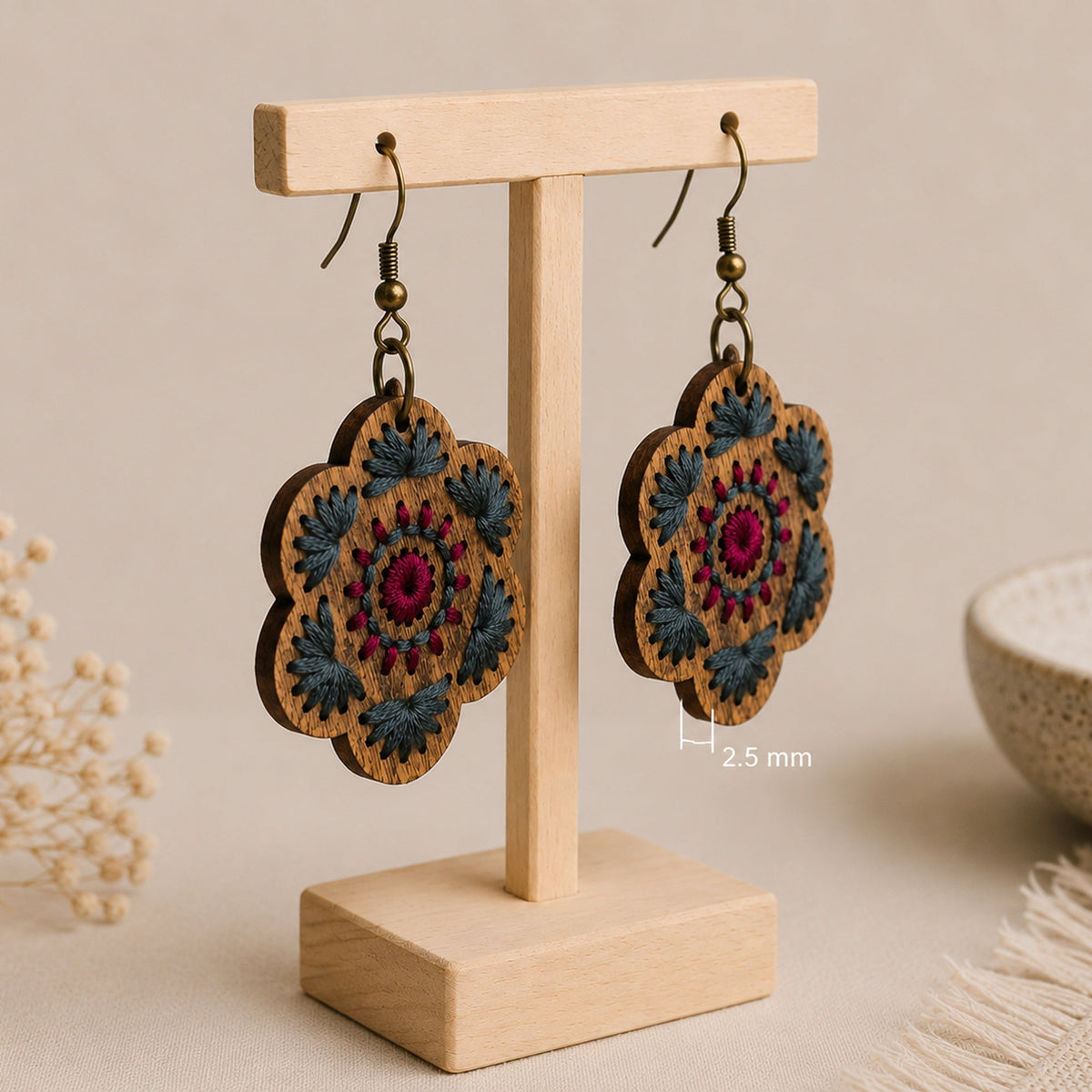 Crimson Roots embroidered wooden earrings shown at an angle to highlight their approximately 2.5 mm thickness.