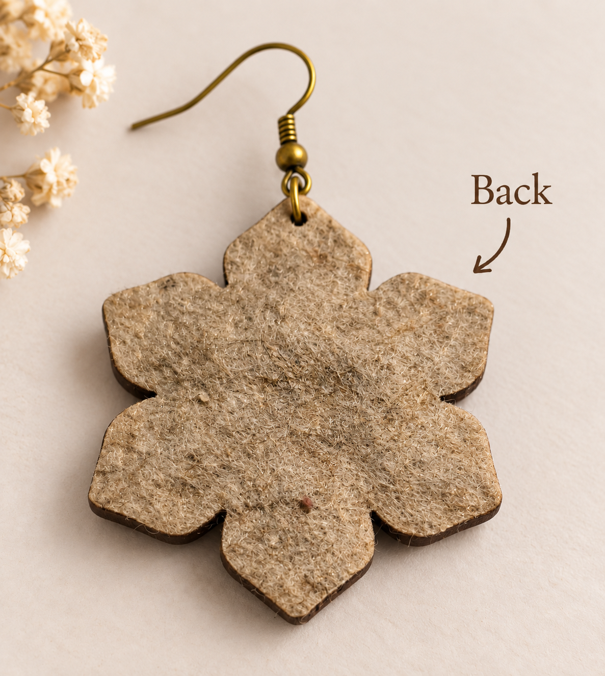 Back view of floral wooden earring showing the real textured felt backing and bronze-tone hook