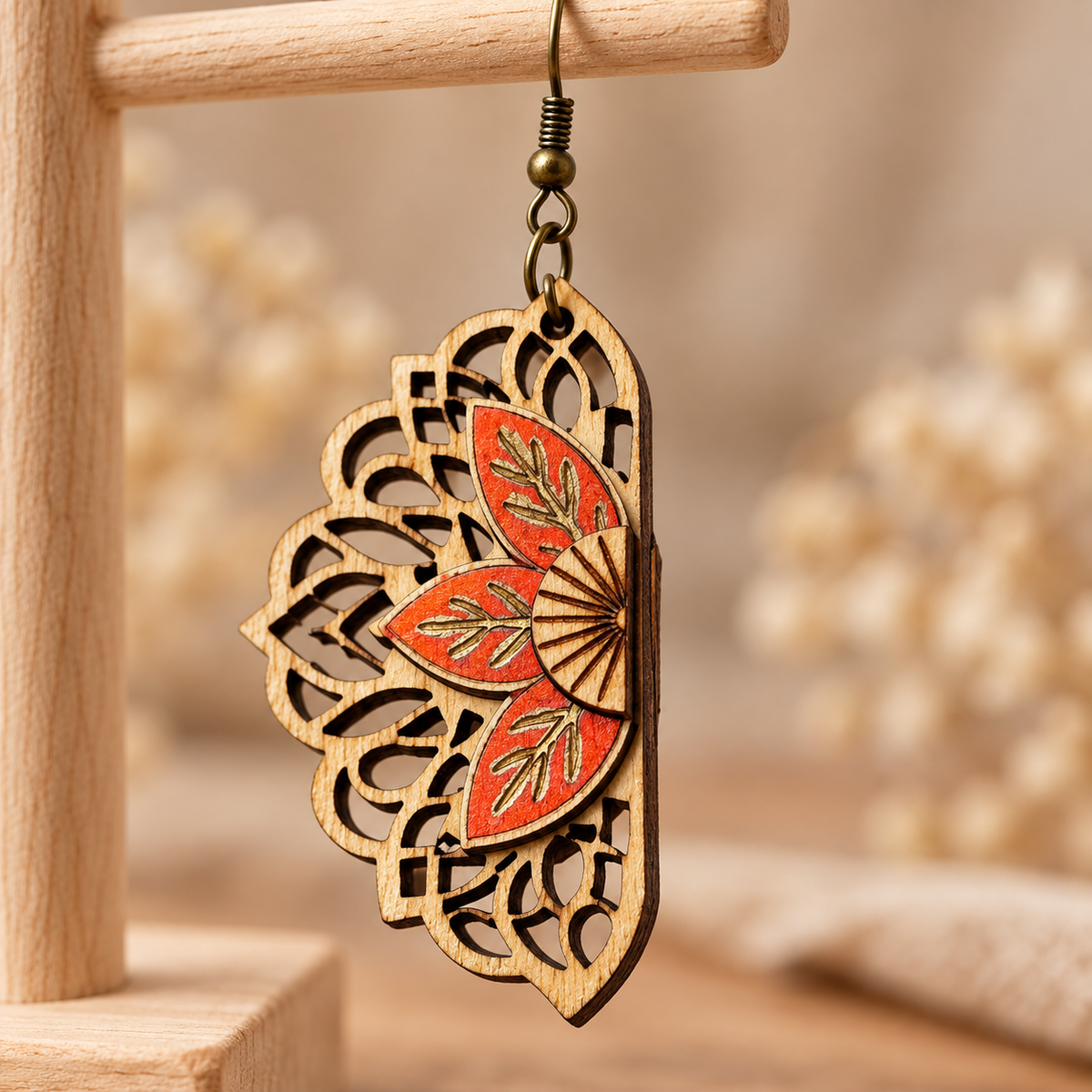 Close-up of a single Floral Mandala earring showing the natural wood texture, coral hand-painted petals, and engraved details.