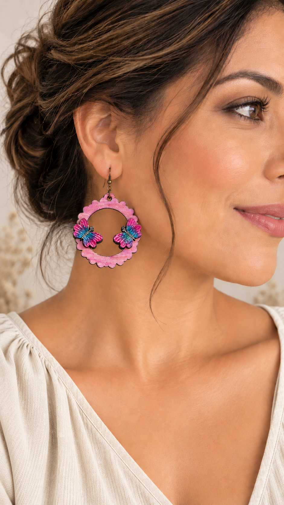 Model wearing Mariposa Serena lightweight layered butterfly wooden earrings with a soft warm ivory oatmeal top