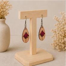 Cargar imagen en el visor de la galería, Mauve Blossom wooden earrings shown at an angle on a light wood stand, highlighting the layered floral construction.
