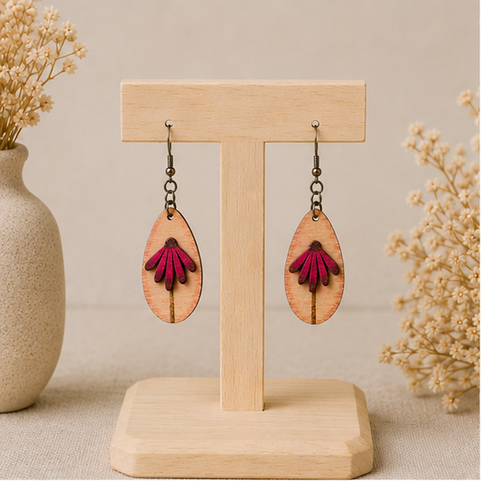 Mauve Blossom wooden earrings displayed front-facing on a light wood stand, showing the layered deep mauve petals and engraved stem.